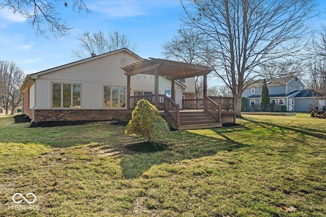 rear view of property featuring a wooden deck, brick siding, a lawn, and a pergola