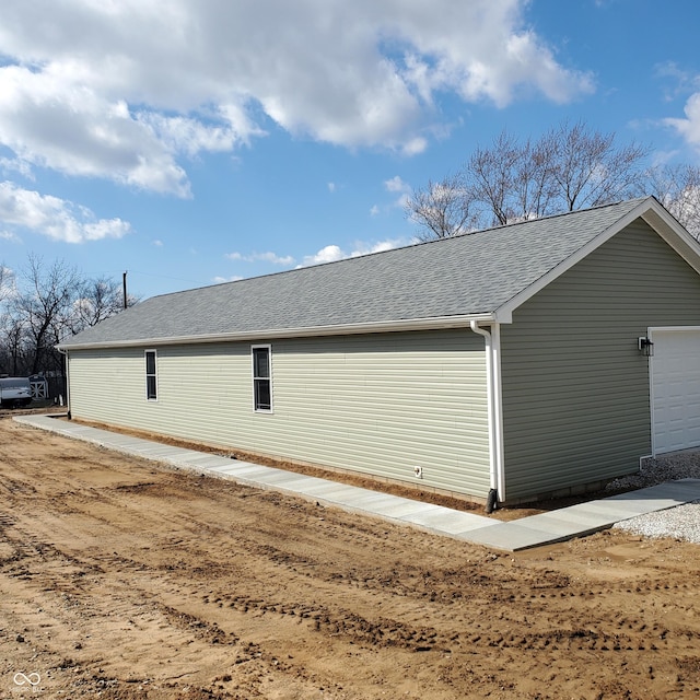 view of side of property featuring roof with shingles