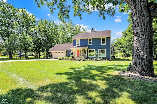 colonial home featuring a garage and a front lawn