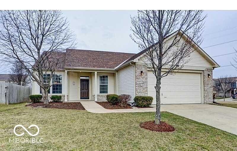 single story home featuring brick siding, a front lawn, fence, concrete driveway, and a garage