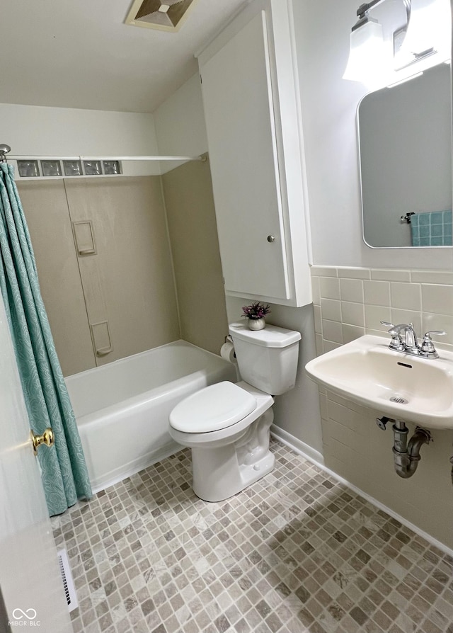 bathroom with visible vents, decorative backsplash, toilet, shower / bathtub combination with curtain, and a sink