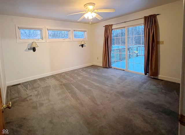 carpeted empty room featuring a ceiling fan and baseboards