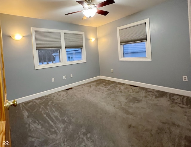 spare room featuring carpet flooring, ceiling fan, visible vents, and baseboards