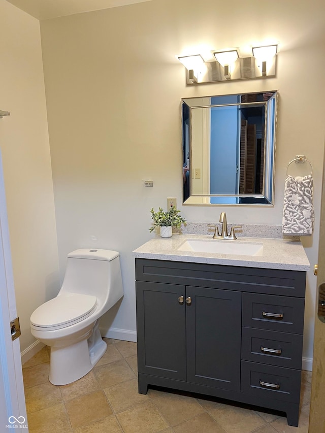 bathroom with vanity, toilet, and baseboards