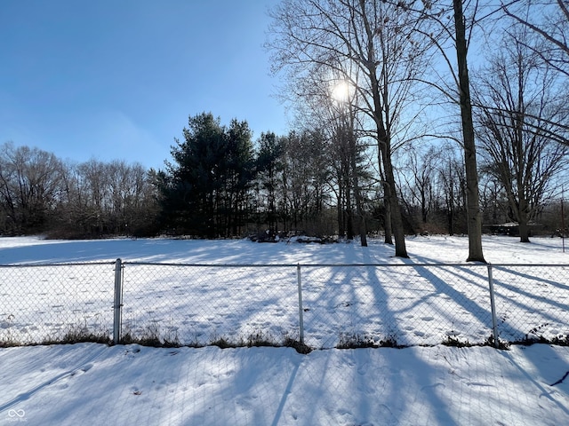 yard covered in snow featuring fence