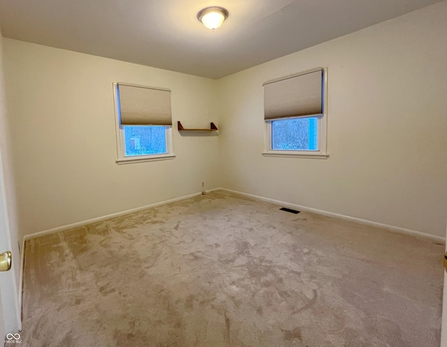 unfurnished room featuring carpet floors, baseboards, and visible vents