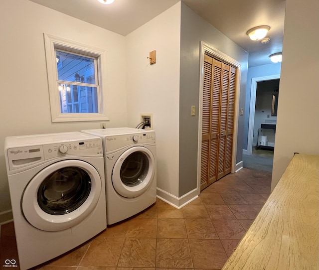 laundry area with laundry area, tile patterned flooring, baseboards, and washing machine and clothes dryer