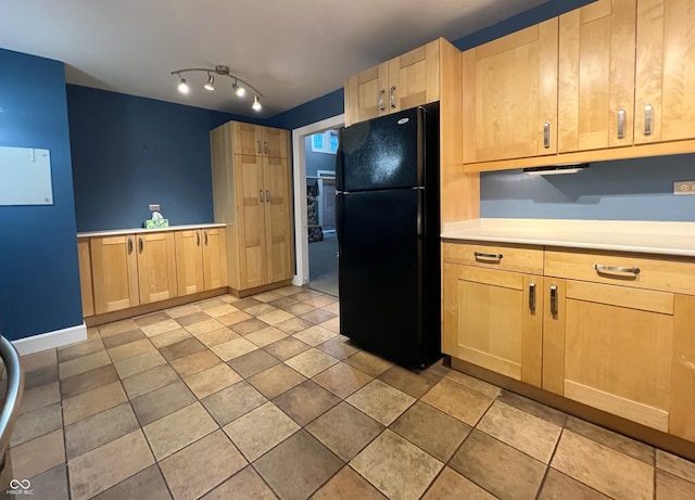 kitchen featuring light brown cabinetry, light countertops, and freestanding refrigerator