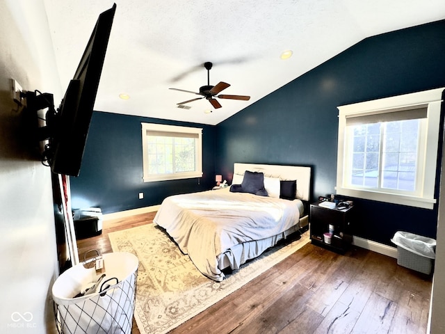 bedroom with lofted ceiling, hardwood / wood-style flooring, a textured ceiling, and ceiling fan