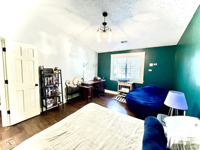 bedroom featuring baseboards, visible vents, wood finished floors, vaulted ceiling, and a textured ceiling