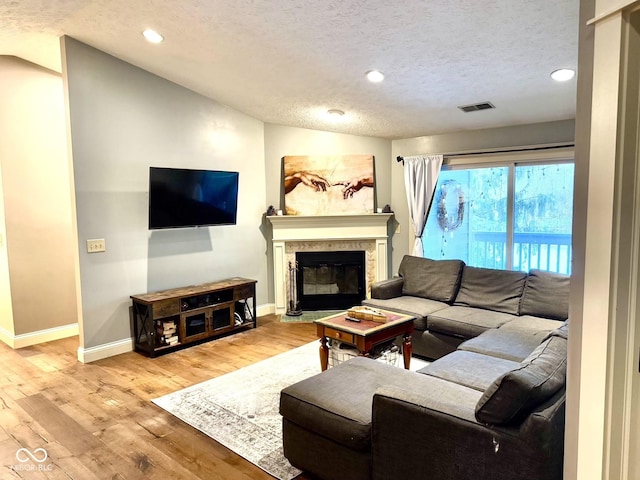 living room featuring light wood-type flooring and a textured ceiling