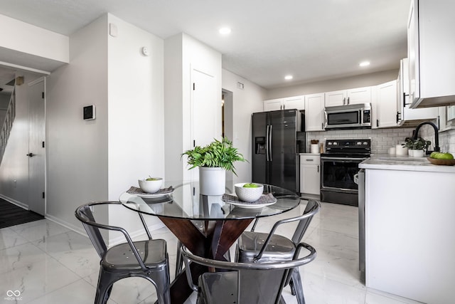 kitchen with sink, tasteful backsplash, black refrigerator with ice dispenser, range with electric cooktop, and white cabinets