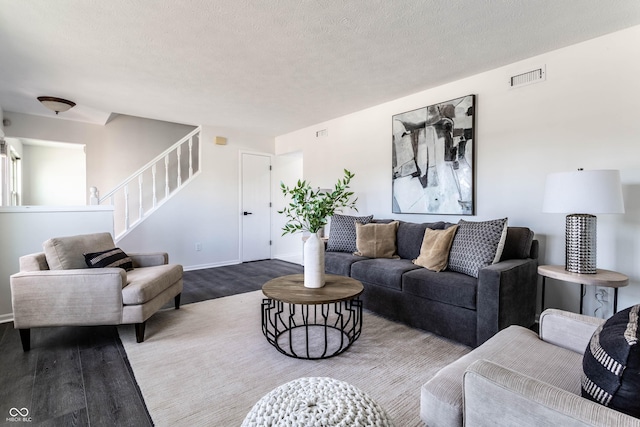 living room with wood-type flooring and a textured ceiling