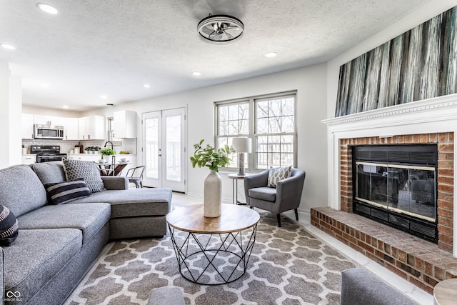 living room featuring a brick fireplace and a textured ceiling