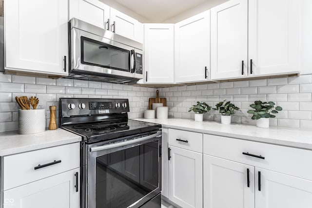 kitchen with white cabinetry, tasteful backsplash, and appliances with stainless steel finishes