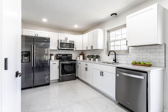 kitchen featuring tasteful backsplash, appliances with stainless steel finishes, sink, and white cabinets