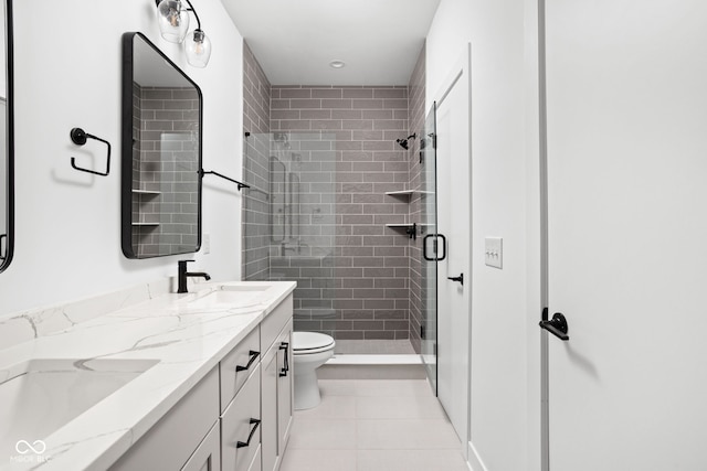 bathroom featuring a shower with shower door, tile patterned floors, vanity, and toilet