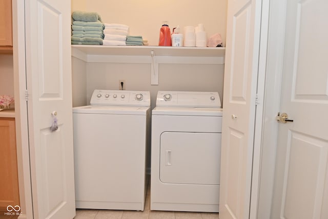 laundry area with light tile patterned floors and washer and dryer