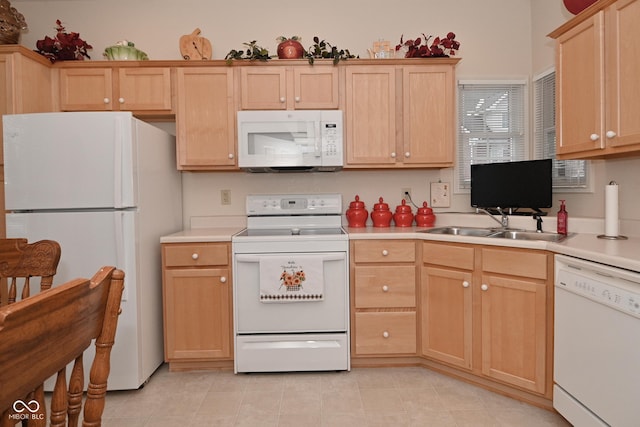 kitchen with white appliances, sink, and light brown cabinets