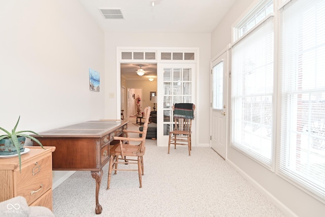 office featuring light carpet, a wealth of natural light, and ceiling fan