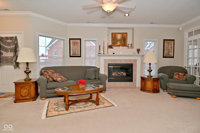 living room featuring crown molding, ceiling fan, a fireplace, and carpet