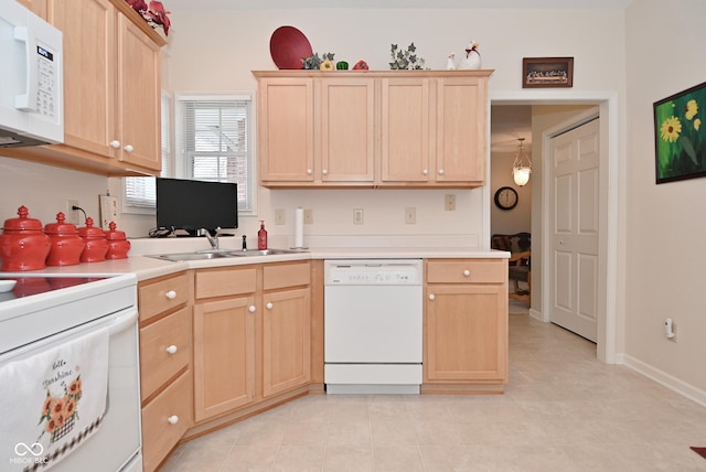 kitchen with white appliances, sink, and light brown cabinets