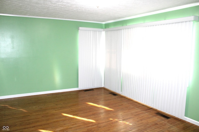 spare room with wood-type flooring and a textured ceiling