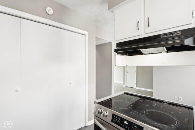 kitchen featuring hardwood / wood-style flooring, white cabinetry, a textured ceiling, and stainless steel electric stove