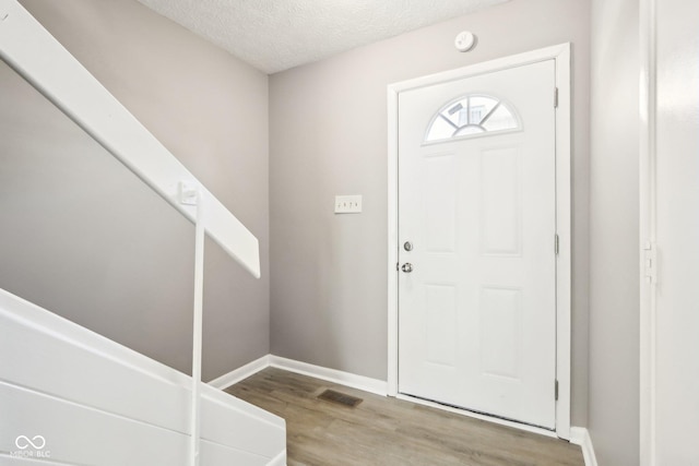 entrance foyer with light hardwood / wood-style flooring and a textured ceiling