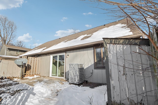 snow covered back of property with central air condition unit