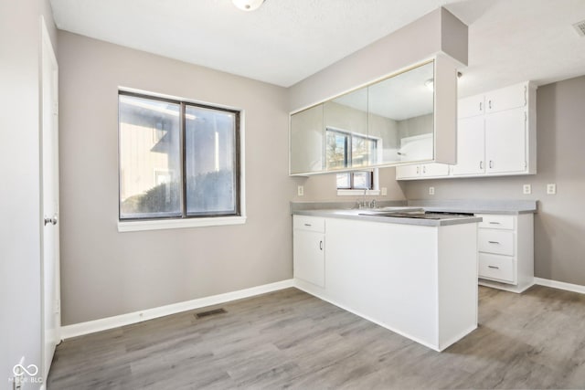 kitchen featuring sink, white cabinetry, and light hardwood / wood-style flooring