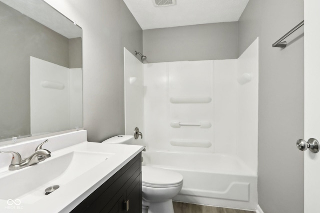 full bathroom with wood-type flooring, toilet, vanity, and shower / washtub combination