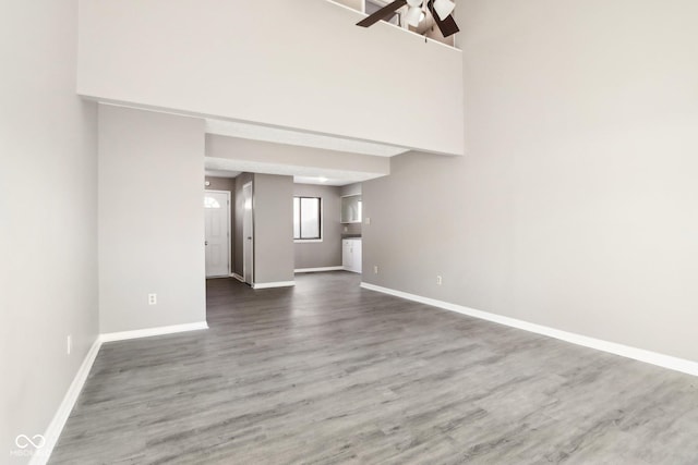 unfurnished living room featuring ceiling fan and wood-type flooring