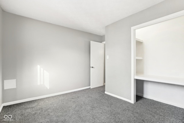 unfurnished bedroom with dark colored carpet