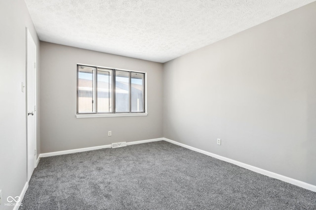 carpeted empty room with a textured ceiling