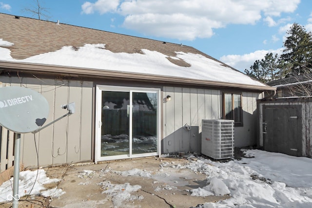 snow covered property featuring central AC unit