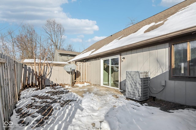 snow covered patio featuring central air condition unit