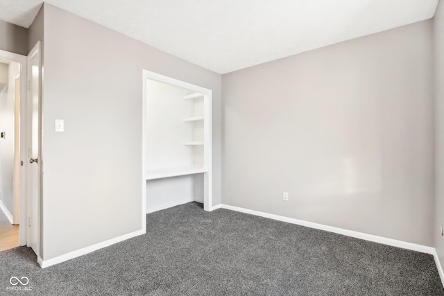 unfurnished bedroom featuring dark colored carpet and a closet