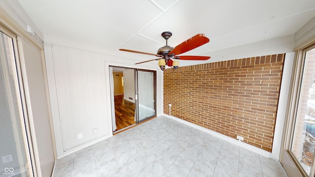 interior space featuring brick wall and ceiling fan