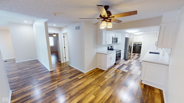 kitchen featuring ceiling fan, appliances with stainless steel finishes, dark hardwood / wood-style flooring, and white cabinets