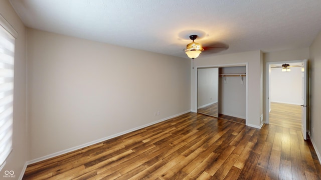 unfurnished bedroom with a closet, dark hardwood / wood-style floors, and a textured ceiling