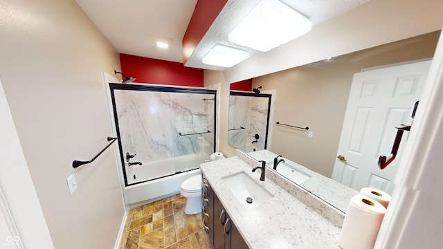 full bathroom with vanity, bath / shower combo with glass door, and toilet