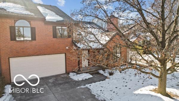 view of snowy exterior featuring a garage