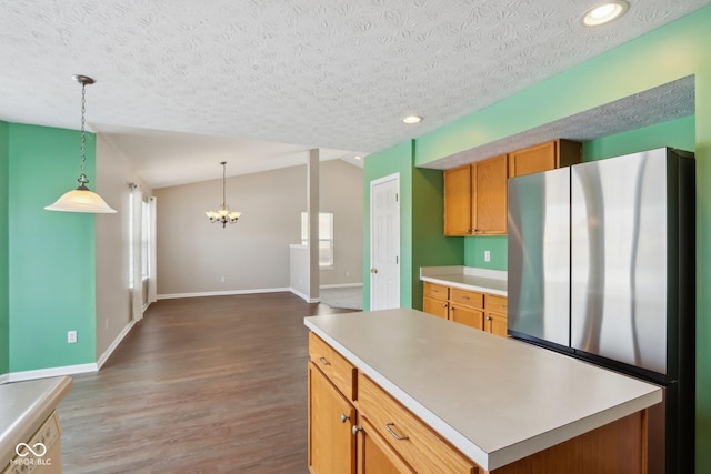 kitchen with plenty of natural light, a textured ceiling, and stainless steel fridge