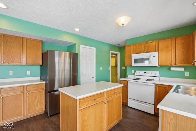 kitchen featuring sink, a kitchen island, white appliances, and dark hardwood / wood-style floors