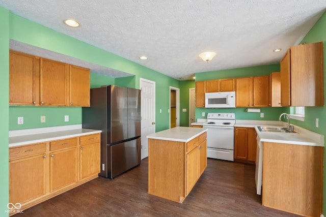 kitchen with a center island, white appliances, a textured ceiling, sink, and dark hardwood / wood-style floors