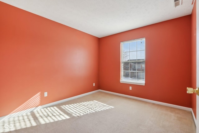 carpeted spare room featuring a textured ceiling