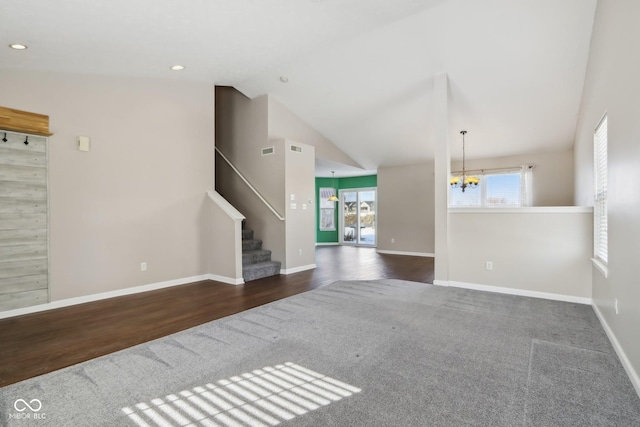 unfurnished living room featuring dark carpet, an inviting chandelier, and vaulted ceiling