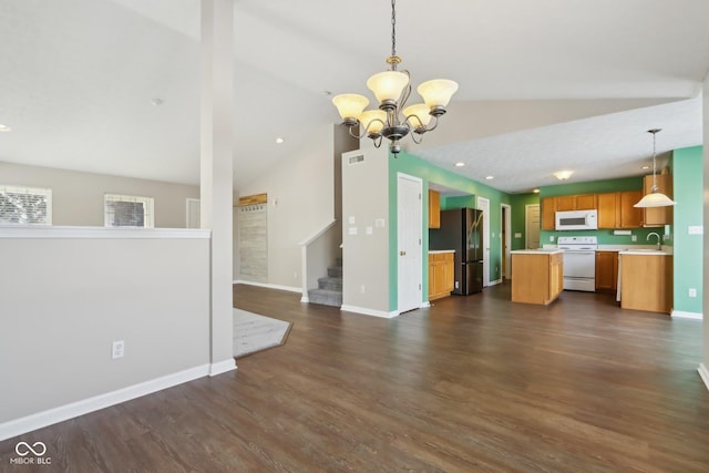 kitchen featuring sink, decorative light fixtures, white appliances, a notable chandelier, and lofted ceiling