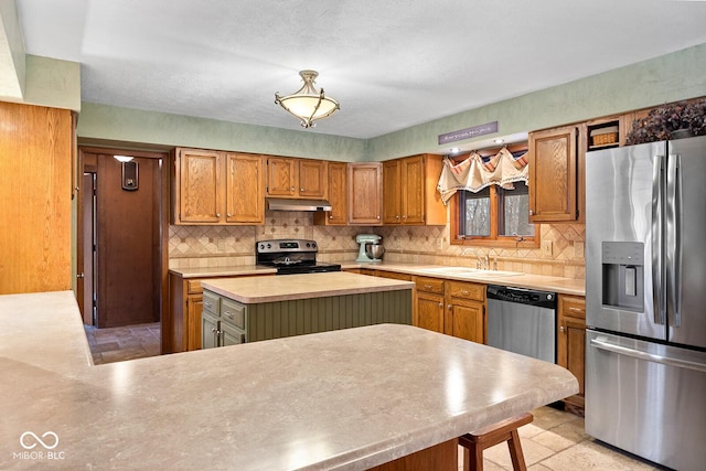 kitchen with sink, a center island, appliances with stainless steel finishes, kitchen peninsula, and decorative backsplash